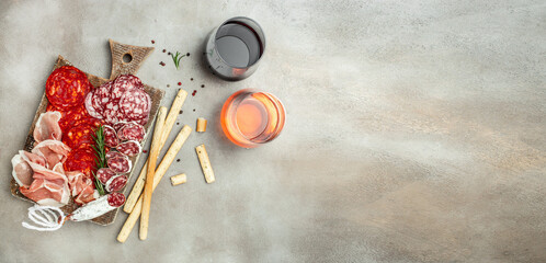 Cold meat plate and grissini bread sticks and wine. Antipasti Dinner or aperitivo party concept. place for text, top view