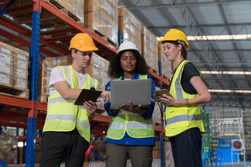 Male and female warehouse workers working checks stock and inventory and standing talking together at storage warehouse. Group of warehouse workers discuss and training work in distribution branch
