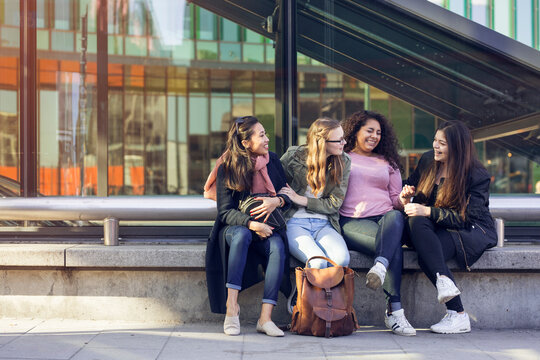 Young women sitting on bench and talking