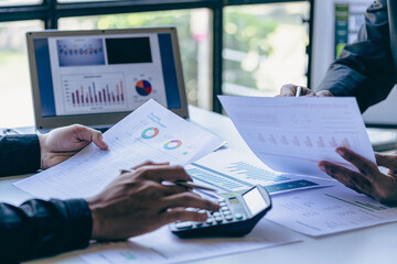 Asian business people meeting with laptop and graph papers to analyze and discuss situation on financial report in conference room investment advisor finance and accounting concept