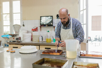 Man cutting cake in bakery