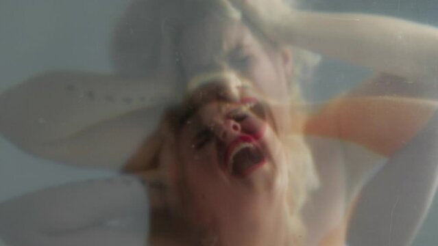Emotional hysteria. Nervous breakdown. Mental disorder. Double exposure defocused silhouette of frustrated mad blonde woman with red lips screaming artistic out of focus.