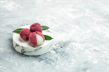 Sweet lychees fruits with leaves on a light background. banner, menu, recipe place for text, top view