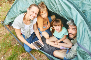 Cheerful family camping together during vacation in forest