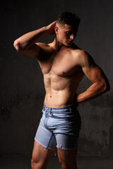 Fototapeta premium Athlete bodybuilder trains in the studio in the rain.