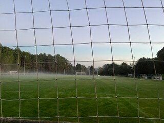 A foggy football field, Low angle of the green grass of a football field. Concept of a sports field