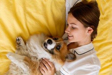girl with corgi dog on the bed hugs and kisses ,dog friend