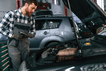 Man in uniform is working in the auto salon