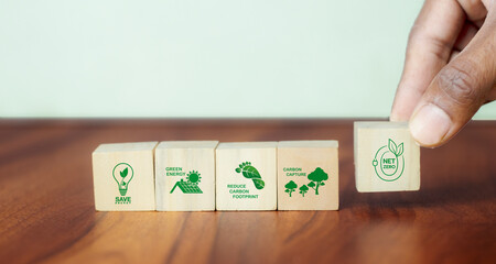 Net zero action concept. Save energy, green energy, reduce carbon footprint, carbon capture. Climate neutral long term strategy. Limit global warming. Putting wooden cubes with green net zero icon