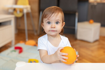 Adorable child playing with orange
