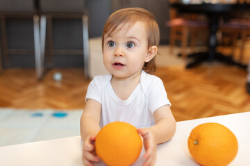 Fototapeta na wymiar Adorable child playing with orange