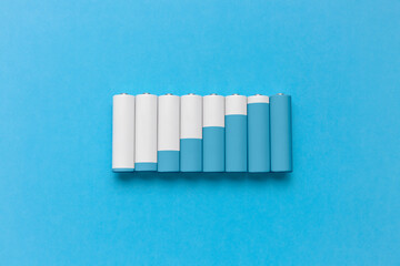 Set of various batteries arranged on blue background