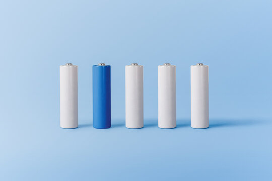 Various white and blue batteries on blue surface