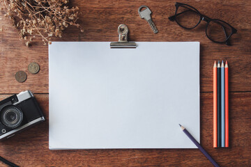 Notebook between various supplies and photo camera