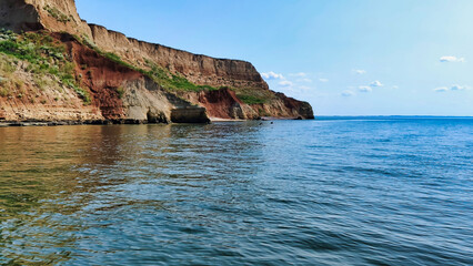 View of the Black Sea and colorful clay cliffs with green grass near Koblevo. Ukraine. Europe	