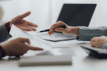 Young colleagues discussing business and price chart analyzes business people on the table great in modern coworking office teamwork concept. Calculate personal tax for customers