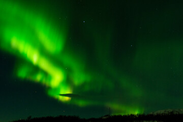 imagen de un paisaje nocturno con montañas nevadas de fondo y una aurora boreal en el cielo de Islandia 