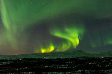 imagen de un paisaje nocturno nevado con una aurora boreal en el cielo de Islandia 