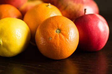 Fruit in a reusable bag. Earth day and zero waste concept. Orange, lemon and apple close-up on a dark background