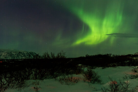 imagen de un paisaje nocturno nevado con una aurora boreal en el cielo de Islandia