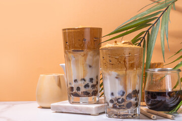 Boba dalgona coffee. Trendy asian latte morning drink with whipped instant coffee and tapioca pearl balls, summer thai bubble cocktail glass in sunny background