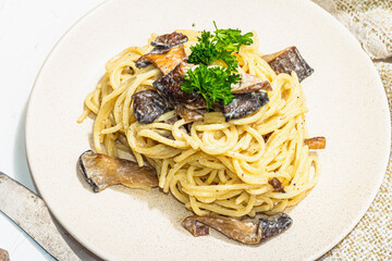 Spaghetti pasta with oyster mushrooms, creamy sauce and parsley. Healthy vegan food ready to eat