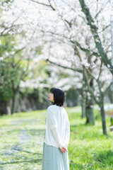 桜の花を見るショートヘアの女性