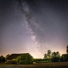 Fototapeta na wymiar Beautiful Milky Way in the night sky over a building in the countryside