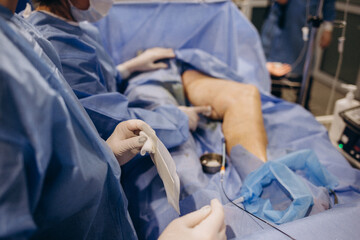 doctor and an assistant in the operating room for surgical venous vascular surgery clinic. - obrazy, fototapety, plakaty