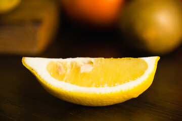 Fruits on a cutting board on a dark background. A lemon slice close-up macro
