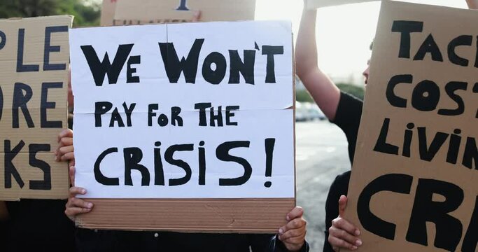 Crowd of diverse people protest against inflation and financial crisis - Protesters marching in the city for rise cost of living while holding up banners