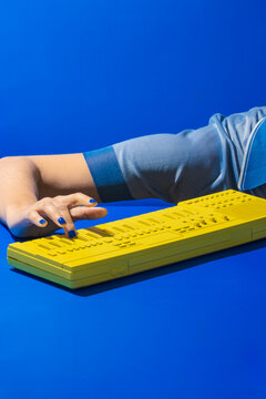 Crop woman playing yellow synthesizer keyboard