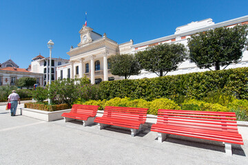 un square près de la mairie d'Arcachon avec des bancs rouges