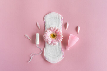 Menstruation period concept. Hygienic white female pad, Menstrual cup and tampon with pink flowers. Menstruation, protection. Women's health - obrazy, fototapety, plakaty