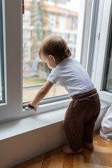 One year old child looking trough the window