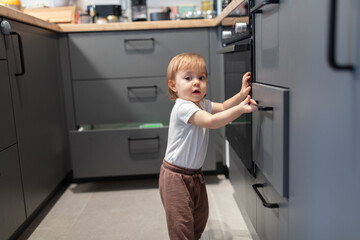 One year old child opening the kitchen drawer