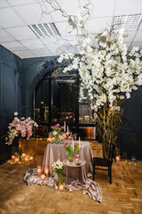 Romantic date. Table setting in restaurant. Luxury candlelight dinner setup table for couple on Valentine's day. Location decoration flowers, decor candles for surprise marriage proposal. Black window