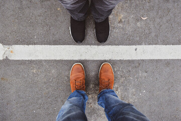 Man and woman standing close on either side of white line. Couple relationship concept.
