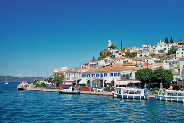 Fototapeta na wymiar Scenic view of Poros island in a typical summer day. Old town with traditional white houses near the sea. Saronic gulf, Greece, Europe.