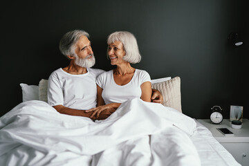 Happiness and tender. Senior family. Husbang hugging his wife in bed.