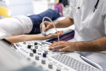 Cropped view of the male doctor holding special device while making ultrasound therapy for woman. Ultrasound of the veins of the upper xtremities concept