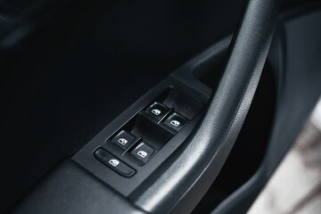 Modern black car interior, black car doors with window control buttons, details interior. 