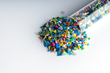 Small pieces of crushed plastic. Crushed bottle caps for recycling. Plastic waste that will be...
