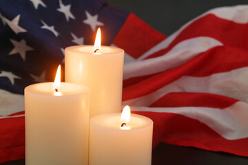 Burning different size candles on wavy USA flag background. Memorial day concept.	