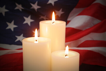 Memorial day concept. Burning candles on USA flag backdrop.