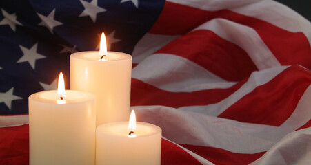 Three burning candles on US flag background. Memorial day concept.	