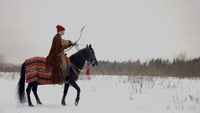 archer riding black horse in winter, historical reconstruction of 12 or 13 century in Ruthenia