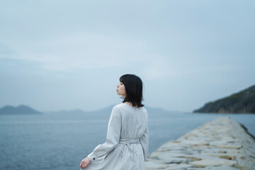 夕暮れの海にいる女性