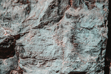 Stone texture of an old rough building wall with cracks, reliefs, plots. Random pattern