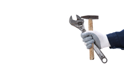 Naklejka premium A worker's hand in a protective glove holds a large old adjustable wrench and a hammer on a white background.